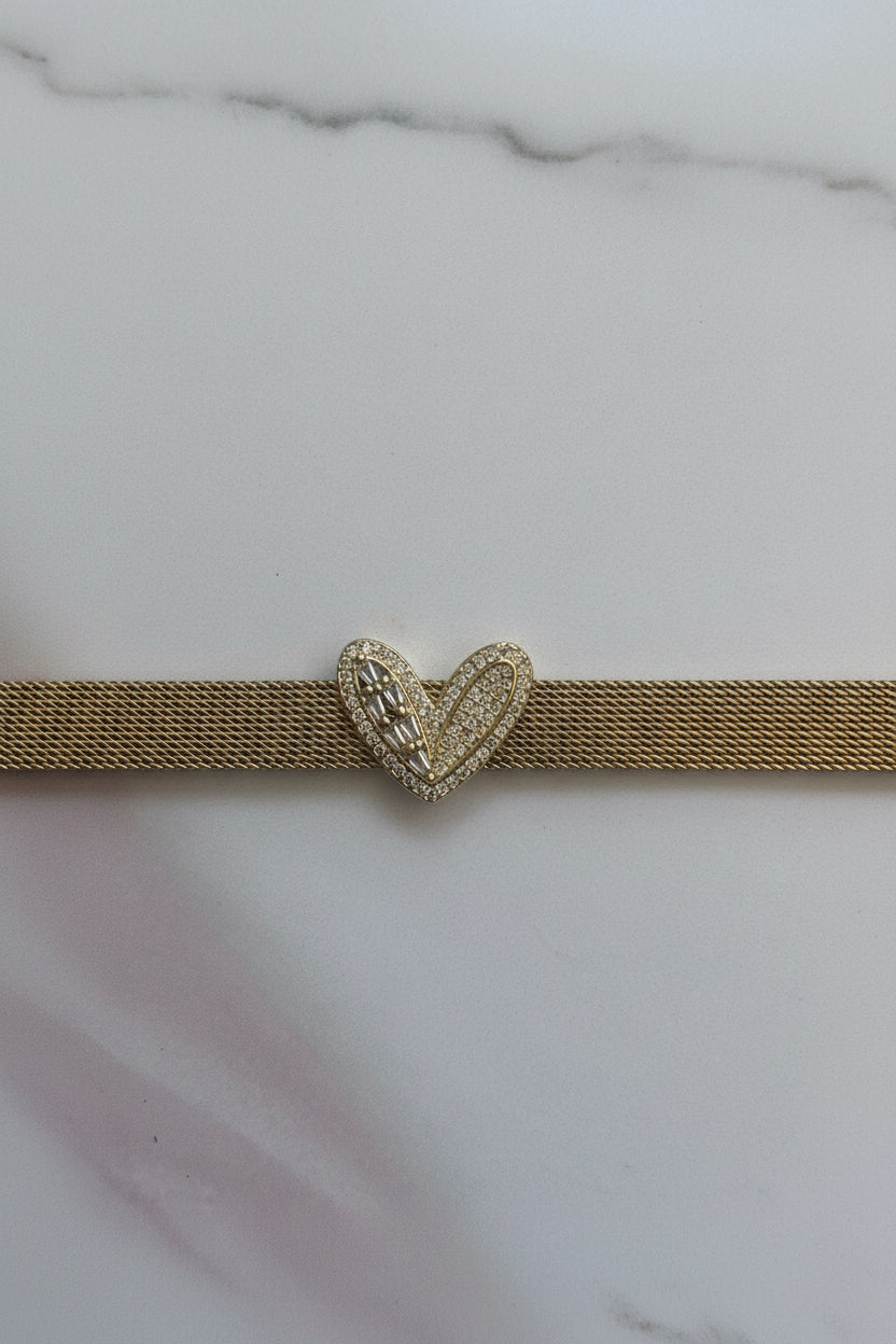 A gold-tone mesh choker necklace featuring a central heart-shaped clasp paved with small clear stones, shown against a plain light background.